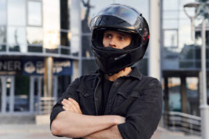 ヘルメットをかぶり顔をしかめ腕組みする男性