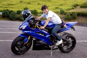 笑顔でバイクにまたがる女性